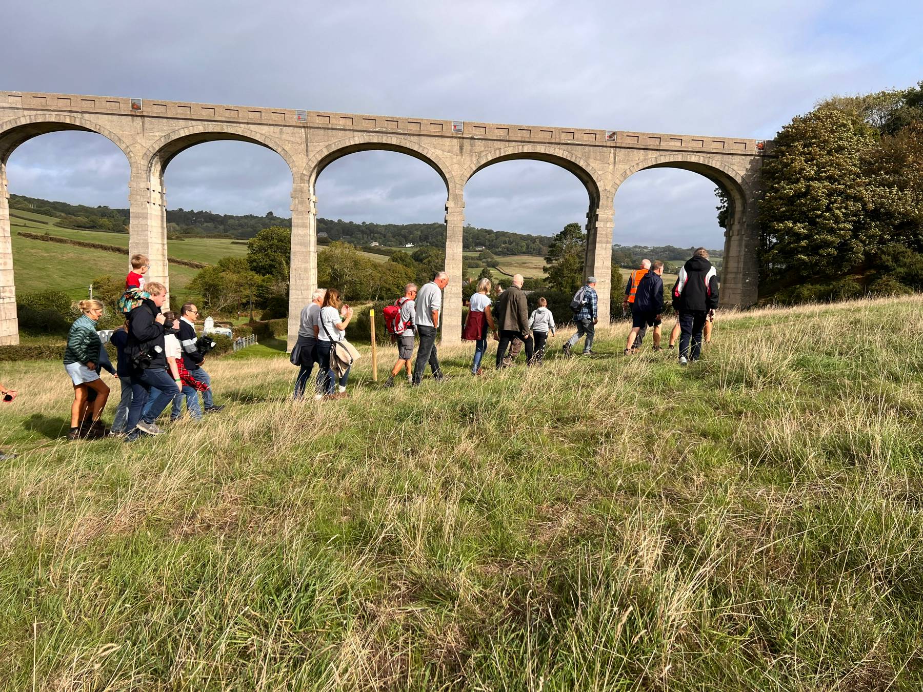 Walkers climbing the field towards the viaduct