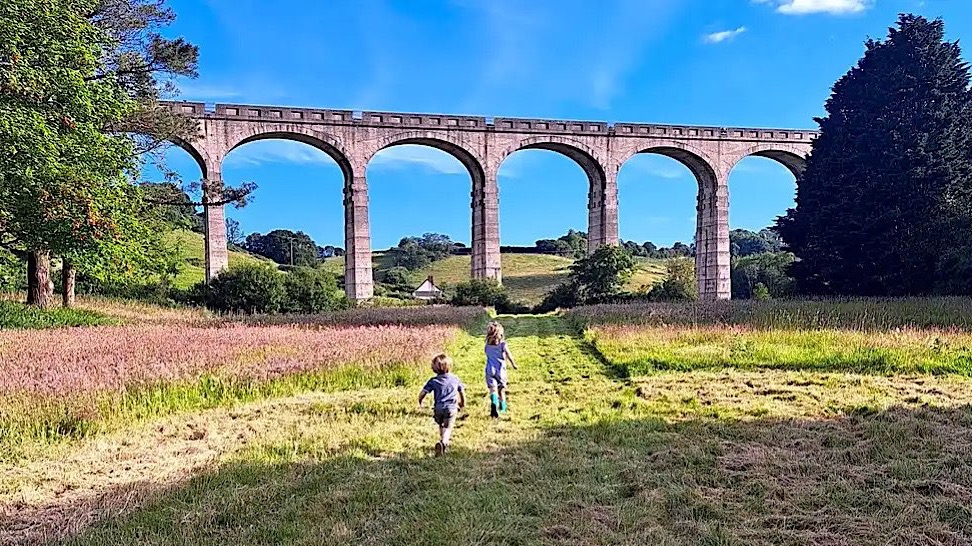 Children running towards viaduct